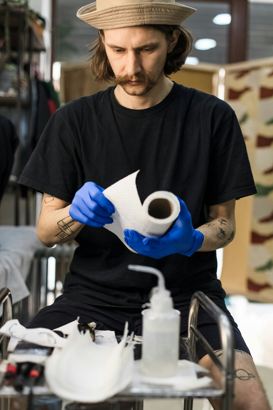Artiste tatoueur disposant ses outils et stérilisant son matériel avant de commencer une séance de tatouage.